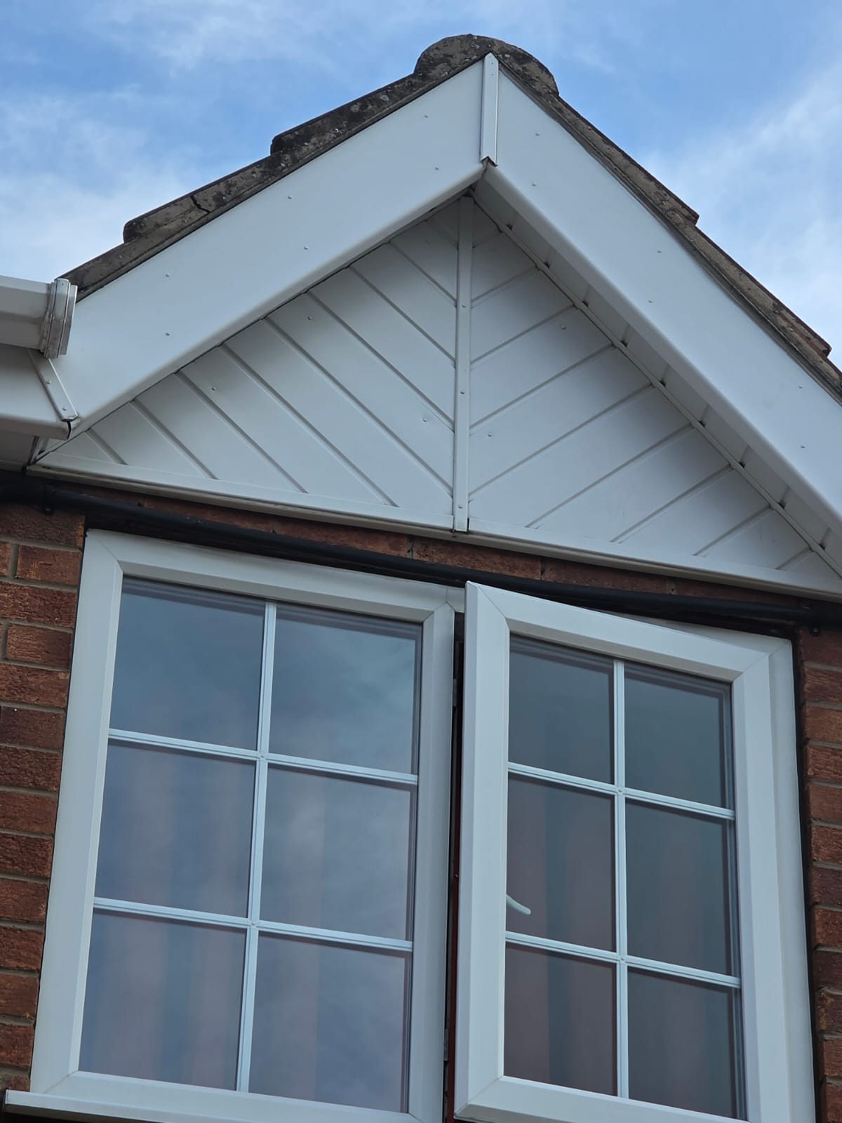 Gable end of a house with finished white verge and fascia trim