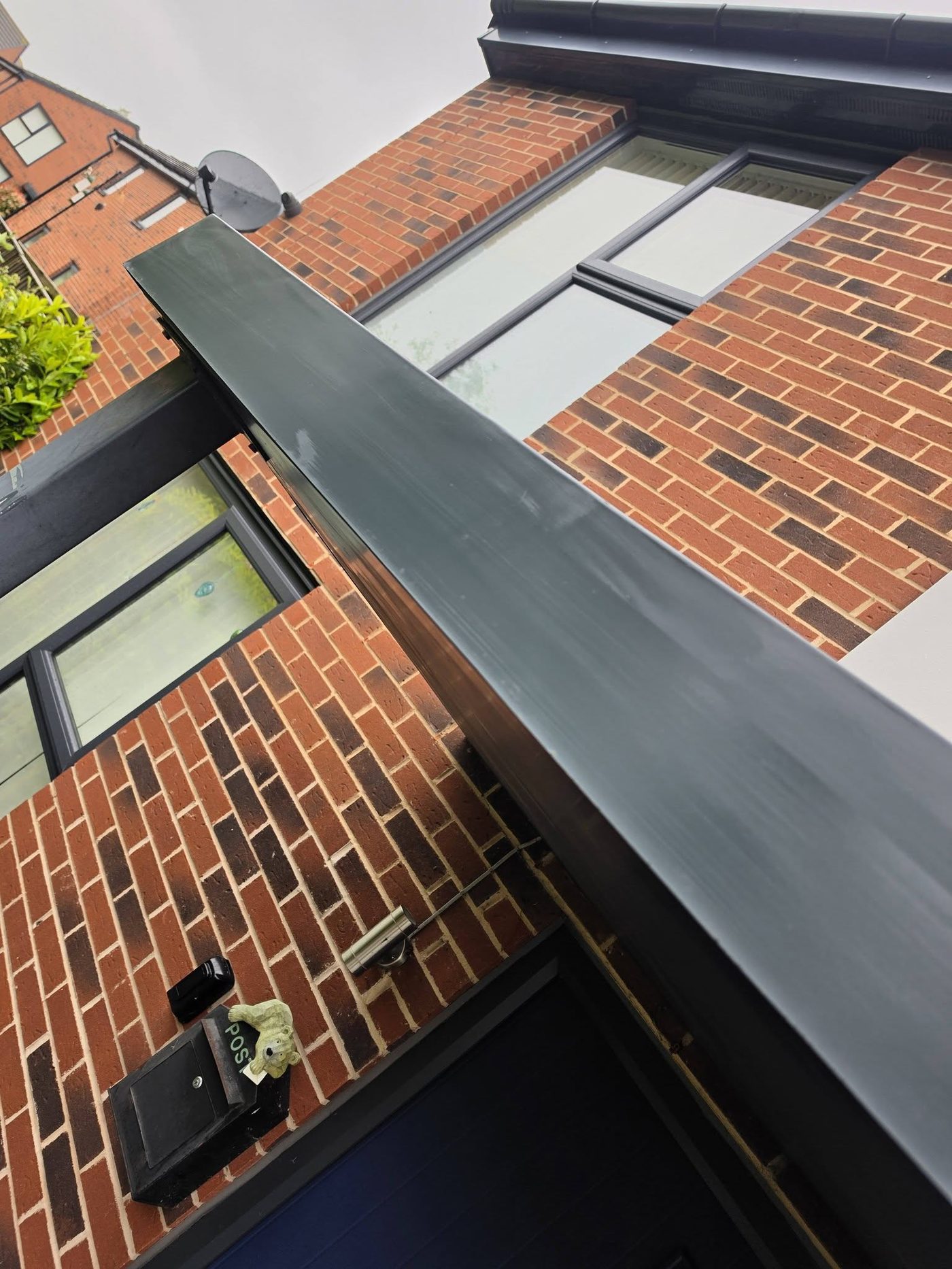 Same grey fascia spotless after moss removal and biocide treatment