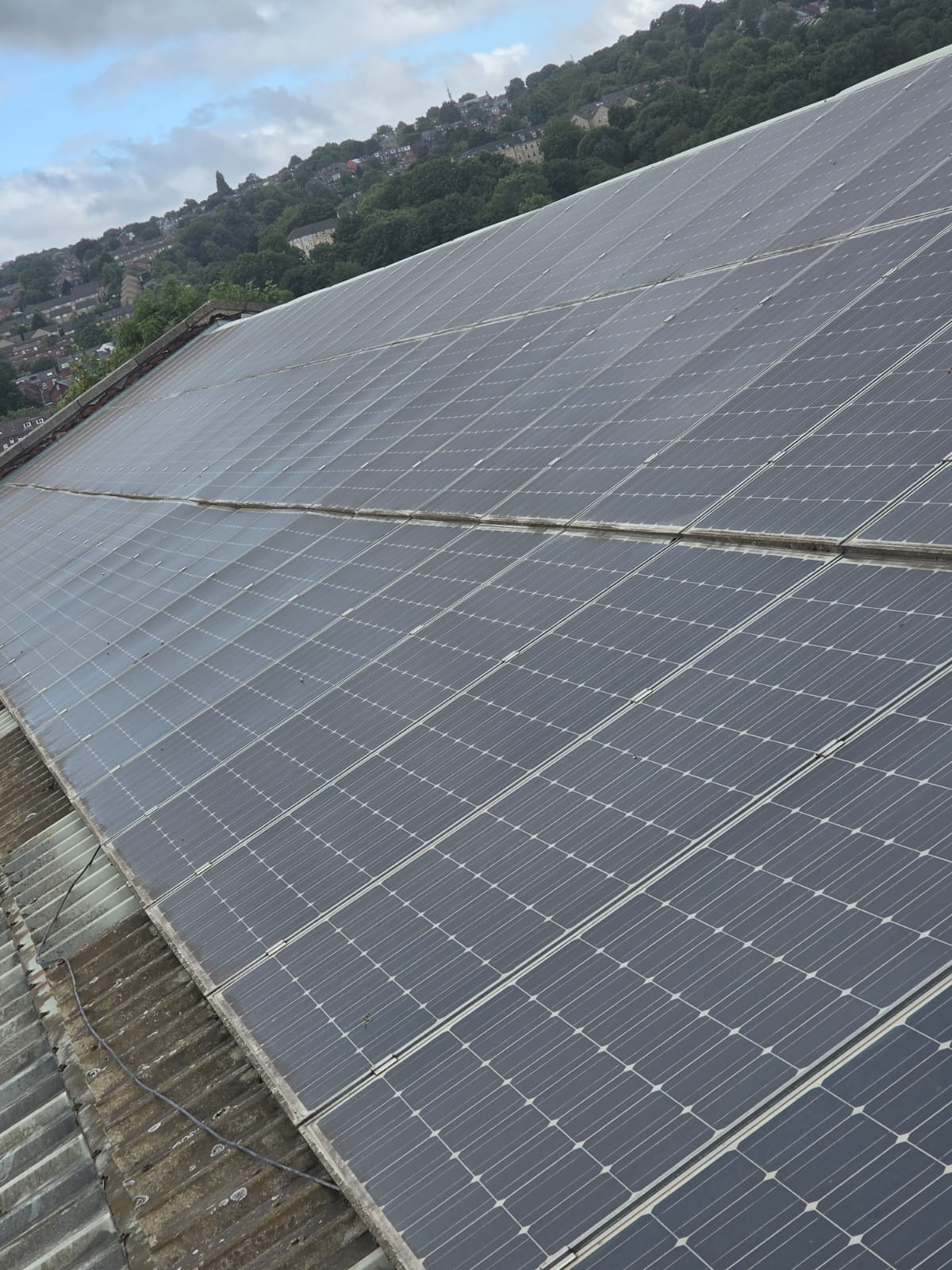 Commercial solar array dulled by dirt and grime before cleaning